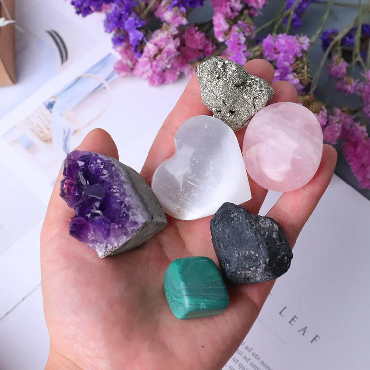 Close-up of a hand gently holding a shimmering crystal, with a serene background, representing the 'Gem Pack: Crystal Set for Every Intention and Manifestation