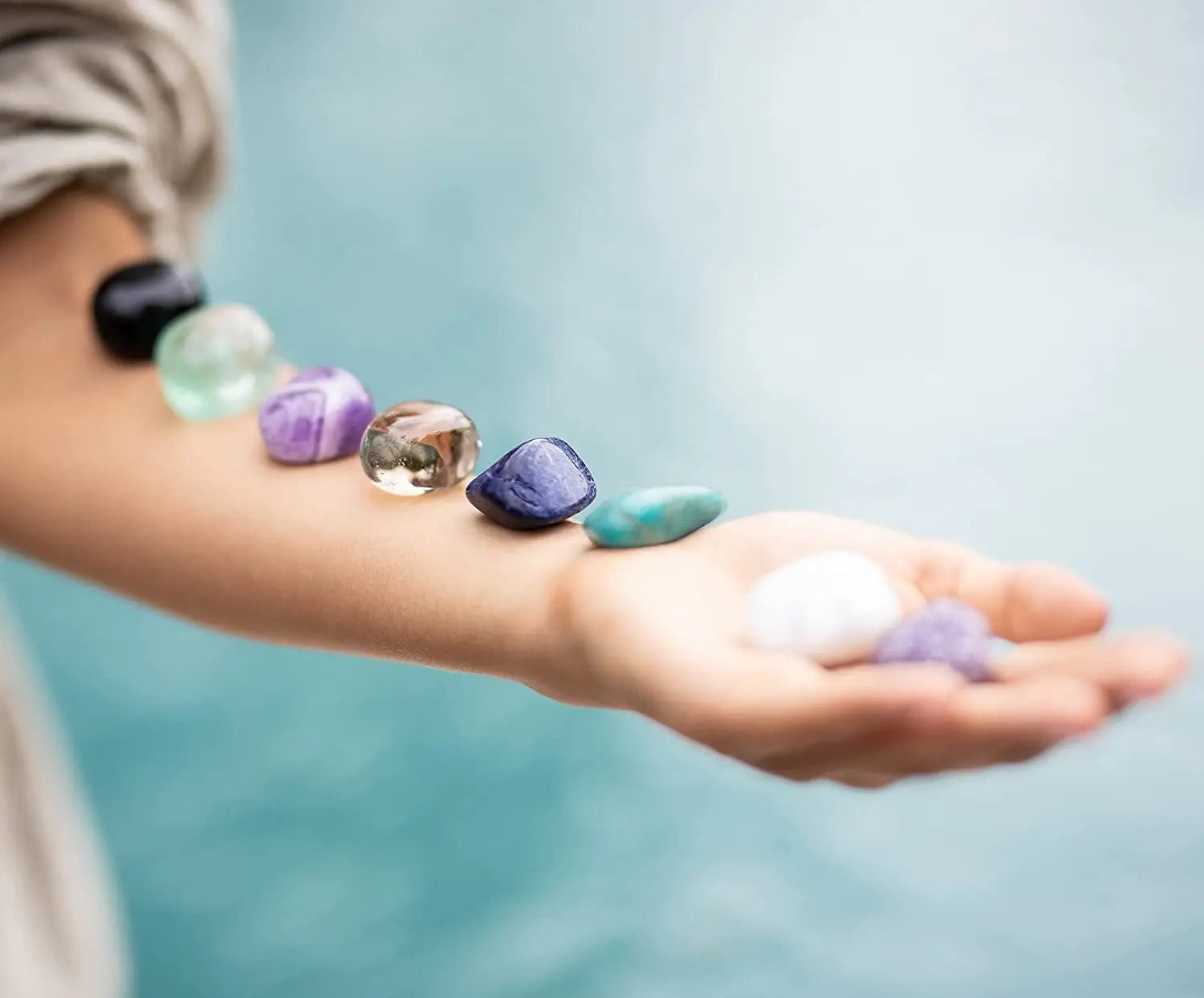 a peaceful girl meditating with a healing crystal placed on her arm, surrounded by a soothing aura of light, symbolizing balance and energy