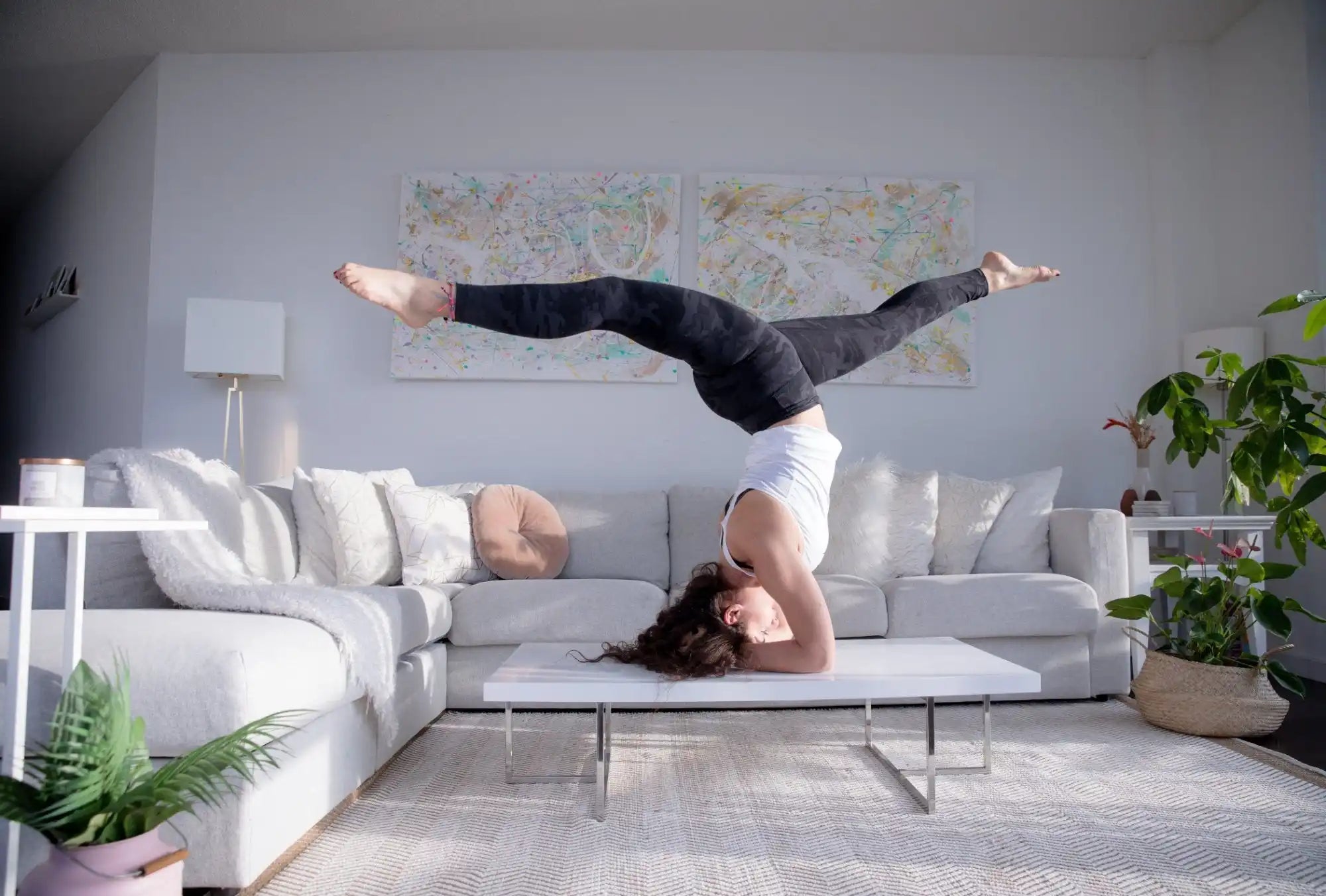 Yoga Headstand balancing on their head on a coffee table